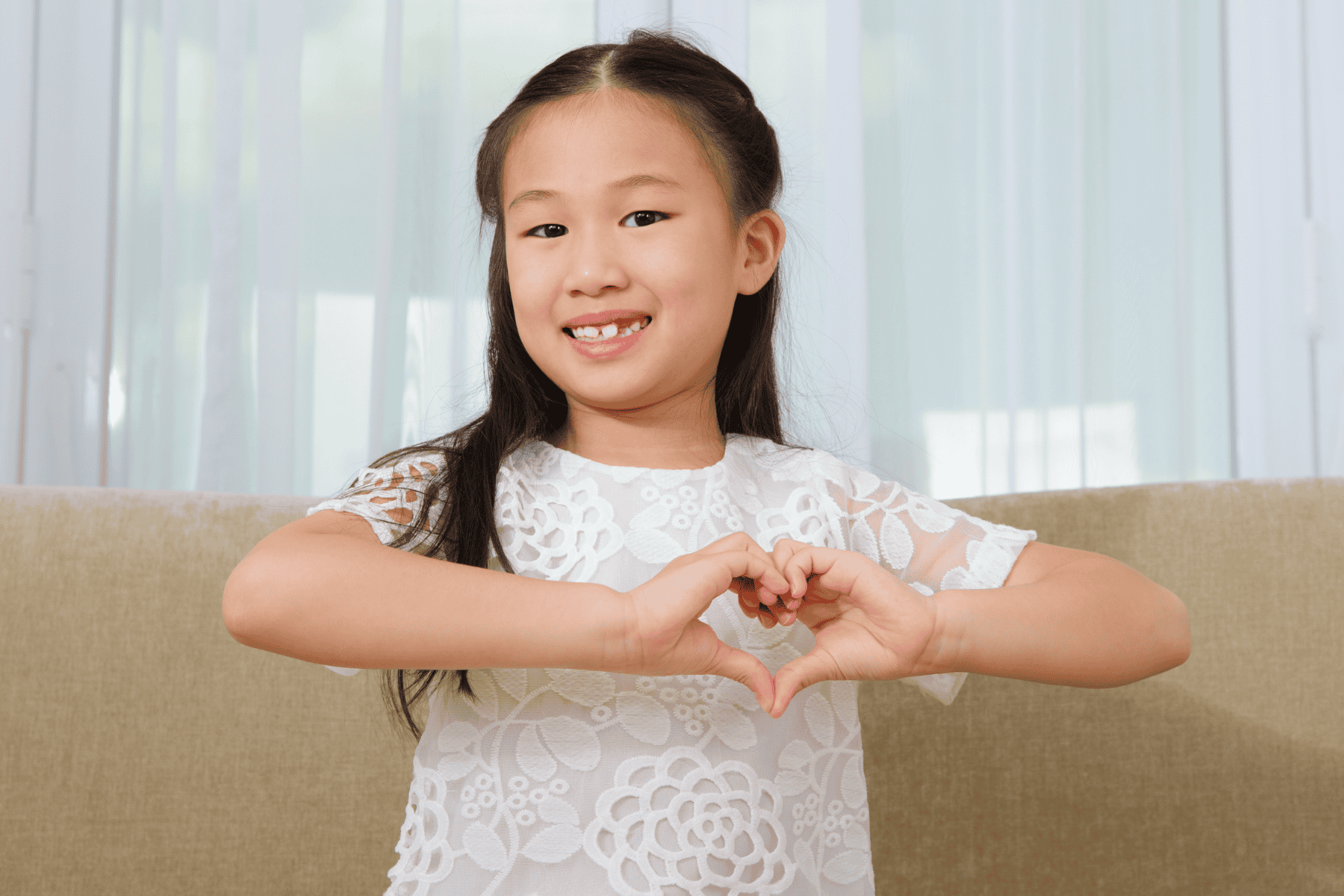 A child making a heart with her hands